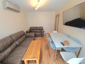 a living room with a couch and a table at London Luxury 2 Bedroom Flat Sleeps 8 free parking in East Barnet