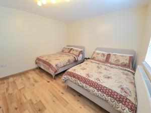 1 dormitorio con 2 camas y suelo de madera en London Luxury 2 Bedroom Flat Sleeps 8 free parking, en East Barnet