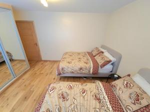 a room with a bed and a couch and a mirror at London Luxury 2 Bedroom Flat Sleeps 8 free parking in East Barnet