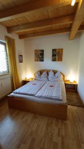 ein Schlafzimmer mit einem großen Bett in einem Zimmer mit Holzböden in der Unterkunft Fasslreiter in Achenkirch