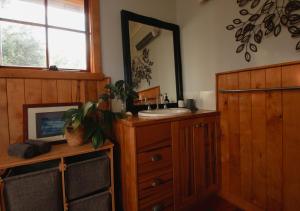 a bathroom with a sink and a mirror and a dresser at Waterfront - Bluff Beach House, Park Beach in Dodges Ferry