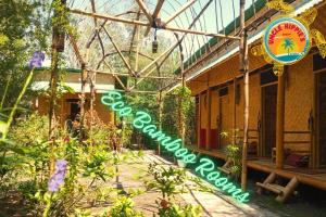 a sign for a greenhouse with flowers in front of a building at Uncle Hippie's Dream in Gili Meno