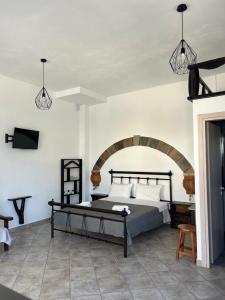 1 dormitorio con 1 cama y TV en la pared en Xanthi Apartments, en Sivota
