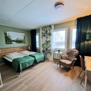 Karesuando的住宿－Kuttainen Lodge，一间卧室配有一张床、一把椅子和窗户。