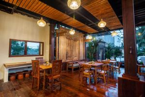 a restaurant with wooden tables and chairs and lights at d'kamala in Ubud
