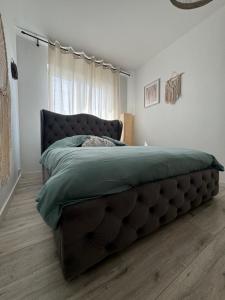 duże łóżko w sypialni z dużym oknem w obiekcie Airport Apartment Regata Kiekrz lotnisko w mieście Baranowo