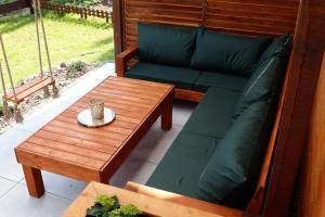 a patio with a couch and a coffee table at Domek w sercu Kaszub in Dziemiany