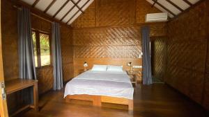 ein Schlafzimmer mit einem weißen Bett in einem Zimmer in der Unterkunft SeaGate Bungalows in Sabang
