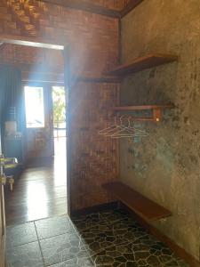 Zimmer mit Ziegelwand und Holzregal in der Unterkunft SeaGate Bungalows in Sabang