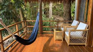 a porch with a hammock and chairs on a deck at SeaGate Bungalows in Sabang