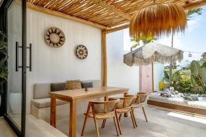 Tumbak Bayuh的住宿－Villa Rosado Canggu，一间带木桌和椅子的用餐室