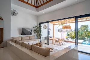 a living room with a couch and a table at Villa Rosado Canggu in Tumbak Bayuh +22 photos