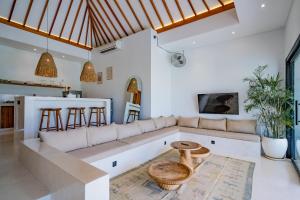 a living room with a couch and a table at Villa Rosado Canggu in Tumbak Bayuh