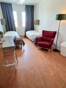 a hotel room with a bed and a red chair at Kuttainen Lodge in Karesuando