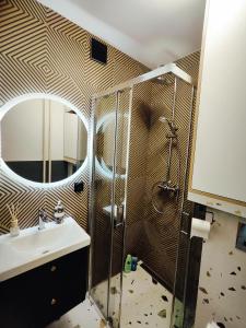 a bathroom with a shower and a sink and a mirror at Apartamenty na Równi w Centrum Apartzakop in Zakopane