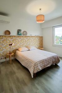 1 dormitorio con cama, lámpara y ventana en Plage à 200 mètres. Vue mer et Esterel ! Rénové en Saint-Raphaël