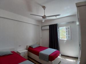 1 dormitorio con 2 camas y ventilador de techo en Bayt Al Jabal luxor en Luxor