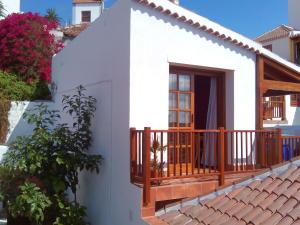a small white house with a wooden balcony at Casa Marilan in Santa Cruz de la Palma