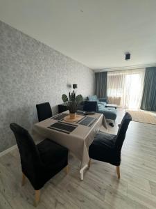 salon ze stołem i krzesłami w obiekcie Airport Apartment Regata Kiekrz lotnisko w mieście Baranowo