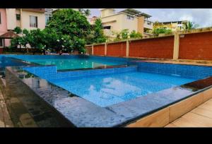 - une grande piscine d'eau bleue dans un bâtiment dans l'établissement Laasya Comforts, à Mangalore