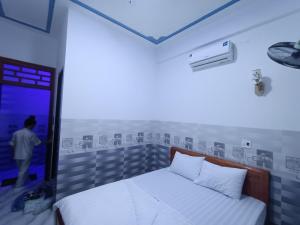 Ein Mann steht in einem Zimmer mit einem Bett in der Unterkunft Khách sạn Trung Dung in Phù Cát