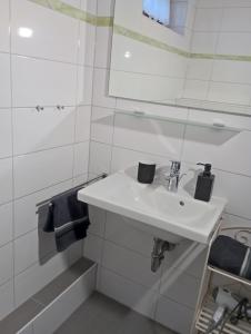une salle de bain blanche avec un lavabo et un miroir dans l'établissement Exklusive Lage - Wohnung mit schönem Garten - Hämmerle Yellow, à Constance 5 autres photos