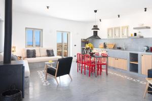 cocina y sala de estar con sillas rojas y mesa en Black Tower Villa, en Apollonia