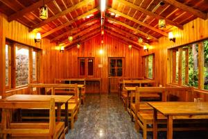 uma sala de jantar com mesas e cadeiras de madeira em Pine Valley Homestay em Nainital