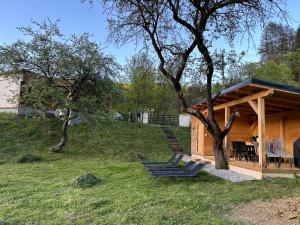 uma cabina de madeira com bancos num quintal em Biutiful Bungalow em Vişeu de Sus