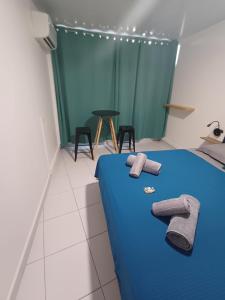 ein Schlafzimmer mit einem blauen Bett und Handtüchern darauf in der Unterkunft Room B777 AF in Papeete