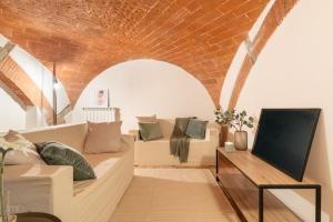 ein Wohnzimmer mit einem Sofa und einem TV in der Unterkunft Fortezza Apartment in Florence in Florenz