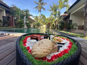 a table with food and flowers in a tire arrangement next to a pool at d'kamala in Ubud