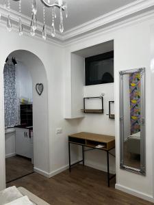 ein Wohnzimmer mit einem Tisch und einem Spiegel in der Unterkunft Silver Hotel in Tbilisi City