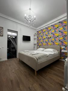- une chambre avec un lit et une peinture murale dans l'établissement Silver Hotel, à Tbilissi