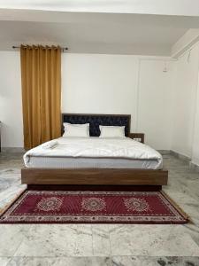 a bedroom with a bed with a red rug at SM LODGE and RESTAURANT in Guwahati