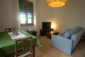 a living room with a green table and a couch at CASA TARTARUGA in La Spezia