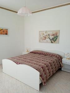a white bedroom with a bed with a red blanket at B&B Villa Rosina in Satriano di Lucania