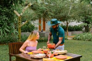 a man and a woman sitting at a picnic table at Four Chalets Yala in Tissamaharama