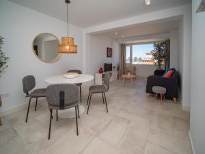 a dining room and living room with a table and chairs at Sibs Sanlúcar Atlantico Playa Vistas Reformado in Sanlúcar de Barrameda