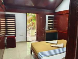 a bedroom with a bed and a sink and a window at SAVITHRI Inn COTTAGE in Varkala