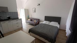 a bedroom with a bed and a dresser and a couch at Apartamenty Jeżynowa 20 in Rowy
