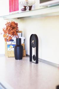 a black object on the floor next to a vase at Quick Home - Magnolia in Viverone
