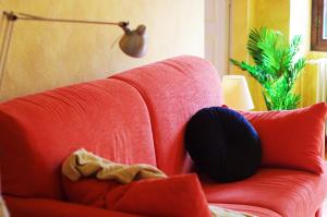 a red couch with pillows on it in a living room at Quick Home - Magnolia in Viverone