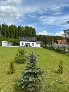 a house with solar panels on it in a field at Dom wakacyjny z sauną i ogrodem na wyłączność in Drawno
