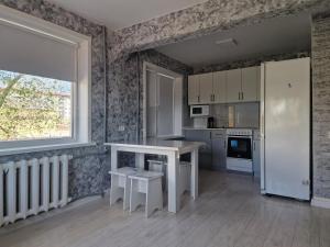 une cuisine avec une table blanche et une fenêtre dans l'établissement Сдаётся однокомнатная квартира возле озера, à Balkhach