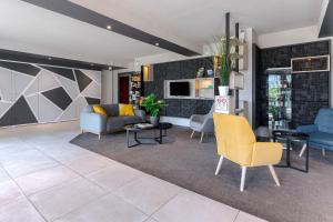 uma sala de estar com um sofá e cadeiras em Zenitude Hôtel-Résidences Nantes Métropole em Nantes