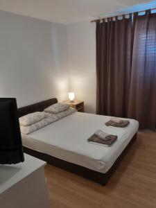 a bedroom with a bed with two towels on it at Apartman Miro in Cavtat