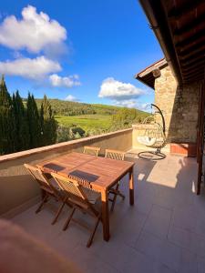 a wooden table and chairs on a patio with a view at Relais Poggio Del Melograno in Montecatini Val di Cecina