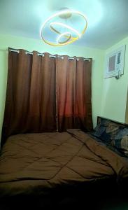1 dormitorio con 1 cama con cortina y lámpara de araña en HeRo's Lair - Staycation near EK with Ps4 & more! en Santa Rosa
