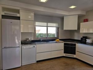 una cocina con electrodomésticos blancos y una ventana en Casa Antonia, en Can Picafort